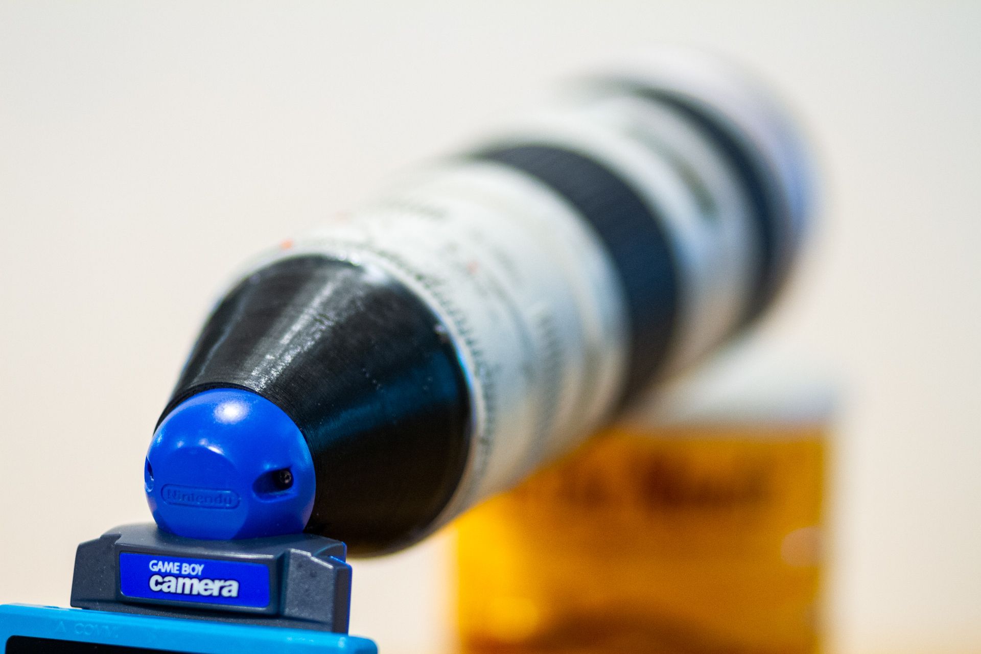 The Canon lens attached to the blue Game Boy Camera