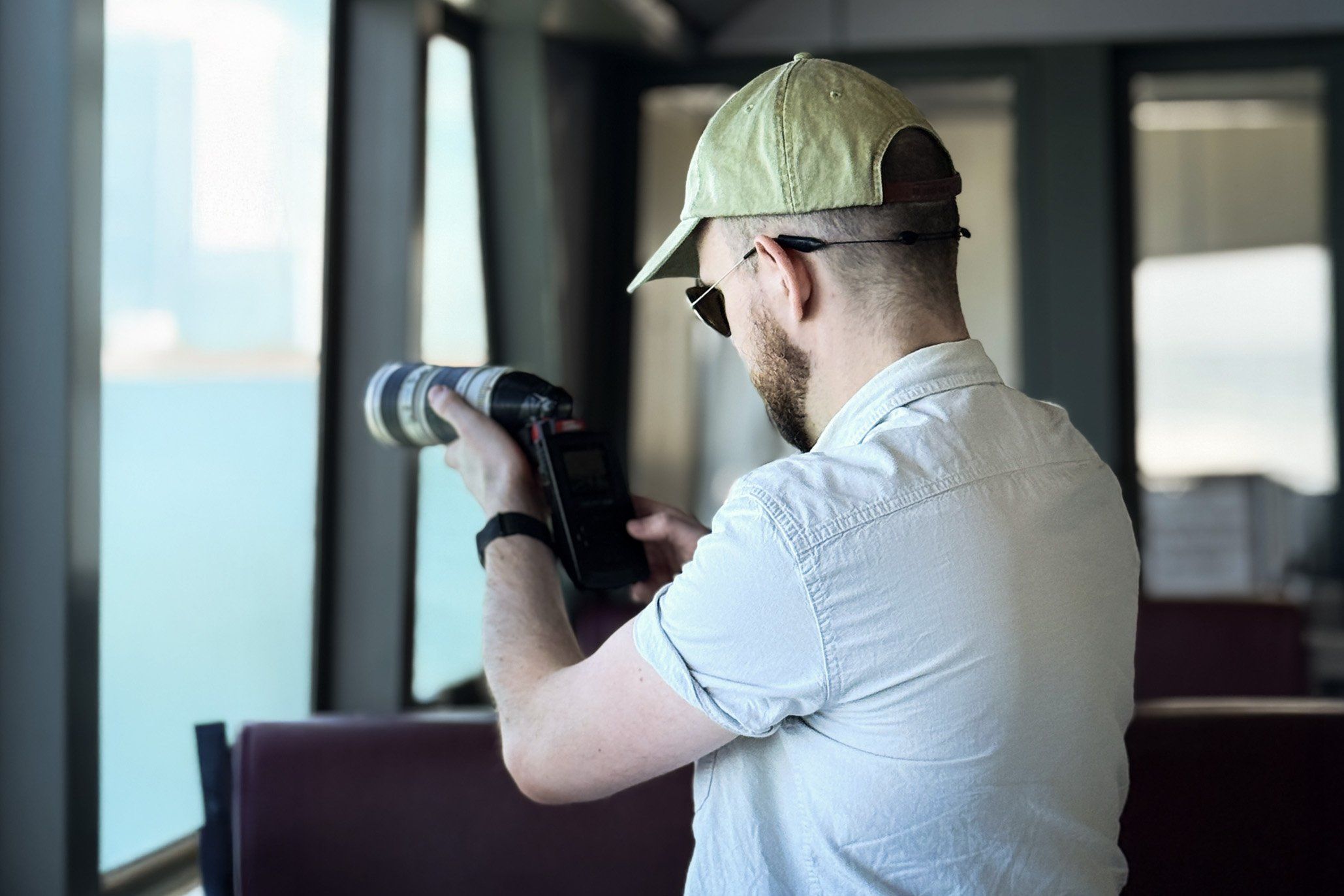 Bastiaan aiming the Game Boy Camera and zoom lens out of a ferry window