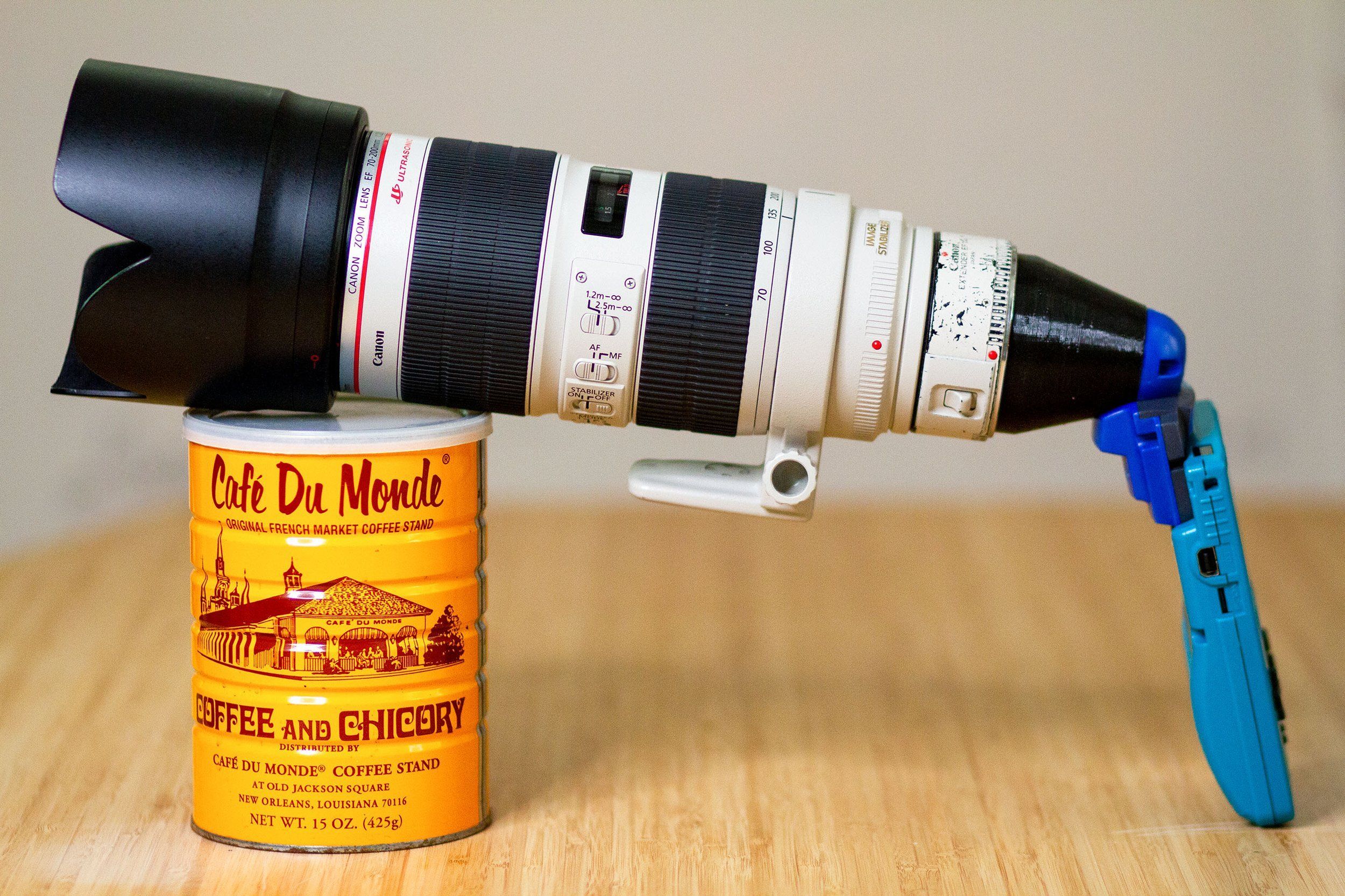 A Canon zoom lens on a homemade Game Boy Camera adapter, resting on a coffee can